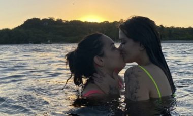 Marcela McGowan troca beijão com Luiza no mar