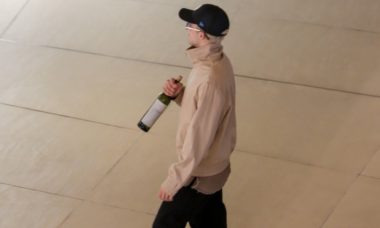 João Guilherme desfila com garrafa de vinho em shopping na Barra da Tijuca