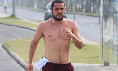 Bruno Gissoni corre pela orla da praia sem camisa no Rio
