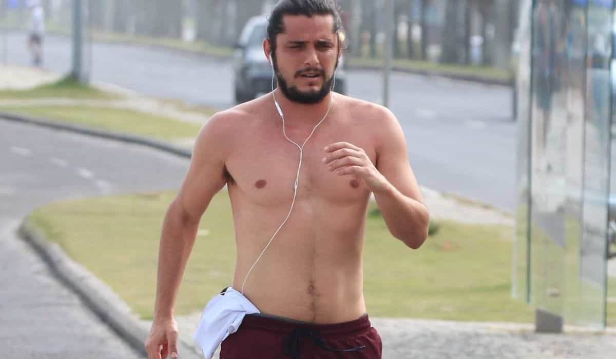 Bruno Gissoni corre pela orla da praia sem camisa no Rio