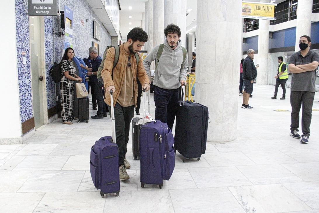 Johnny Massaro desembarca com o namorado em aeroporto do Rio