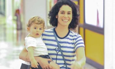 Maria Flor passeia por shopping do RJ com o filho no colo