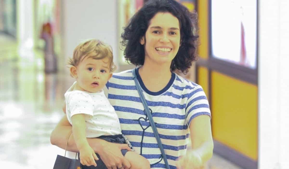 Maria Flor passeia por shopping do RJ com o filho no colo