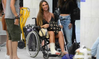 Nicole Bahls é vista de cadeira de rodas após quebrar o tornozelo