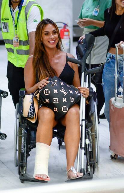 Nicole Bahls é vista de cadeira de rodas após quebrar o tornozelo (Foto: Webert Belecio / AgNews)