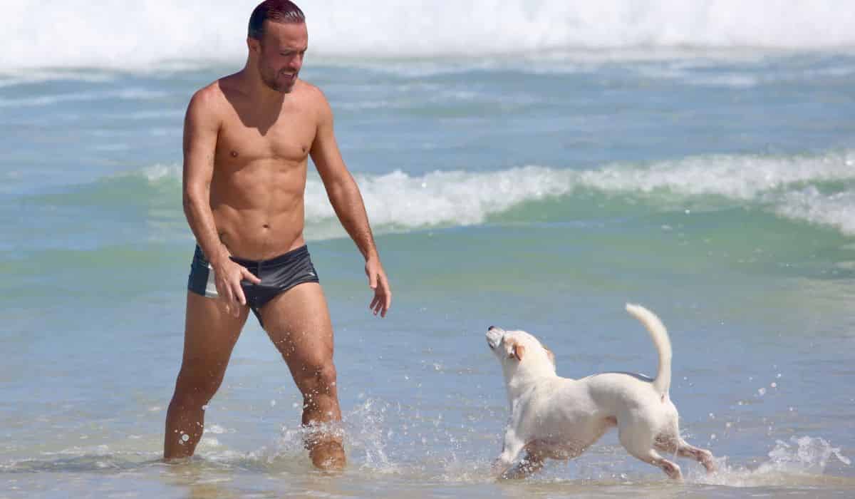 Roger Flores curte dia de praia com o cachorrinho no RJ