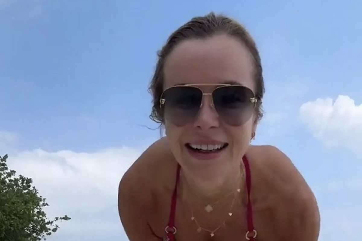 Amanda Holden viser nesten for mye mens hun filmer video på en øde strand