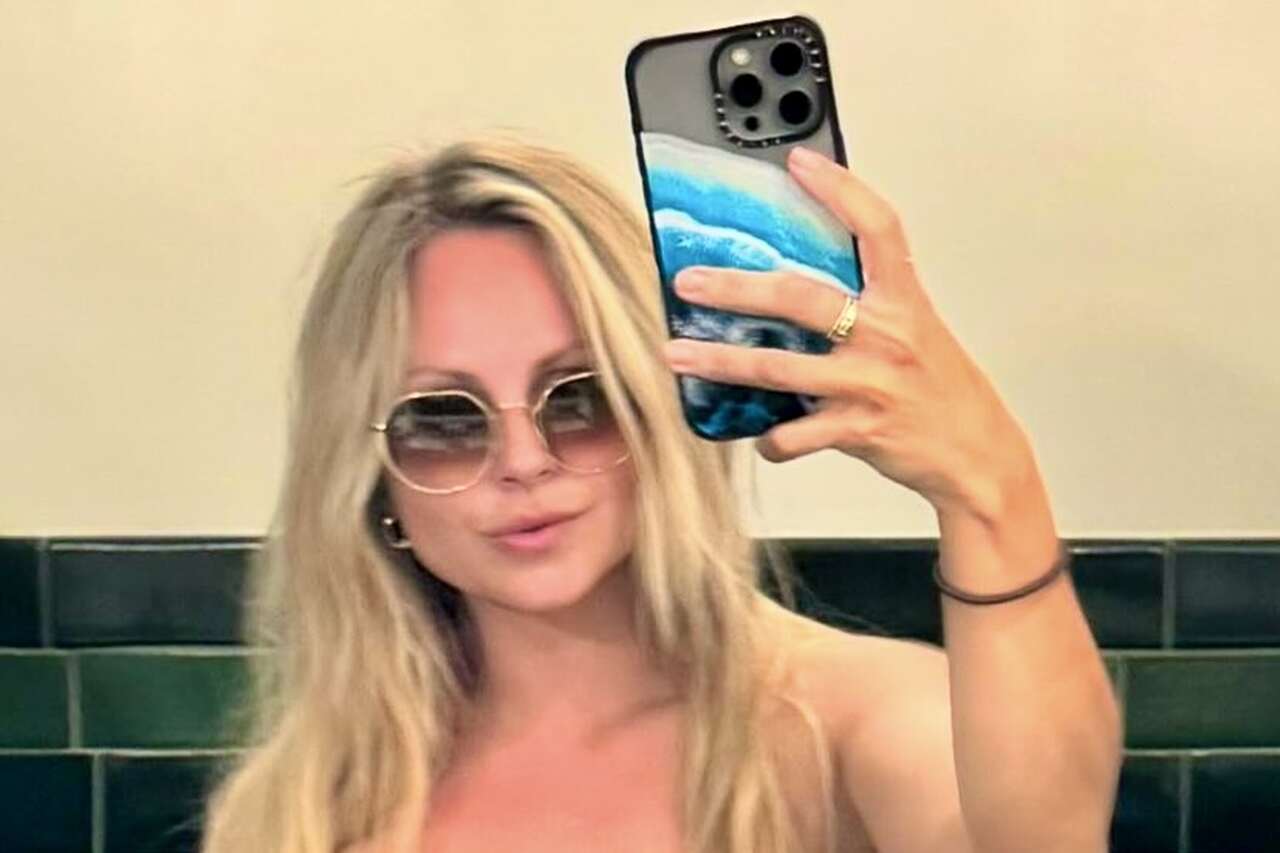 Tina O’Brien poses in a strapless bikini and almost shows too much